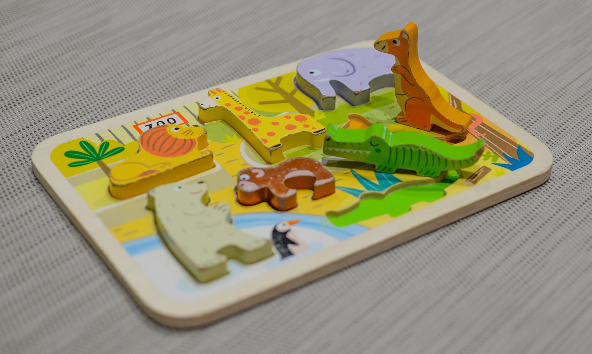 A wooden zoo puzzle on a nursery table